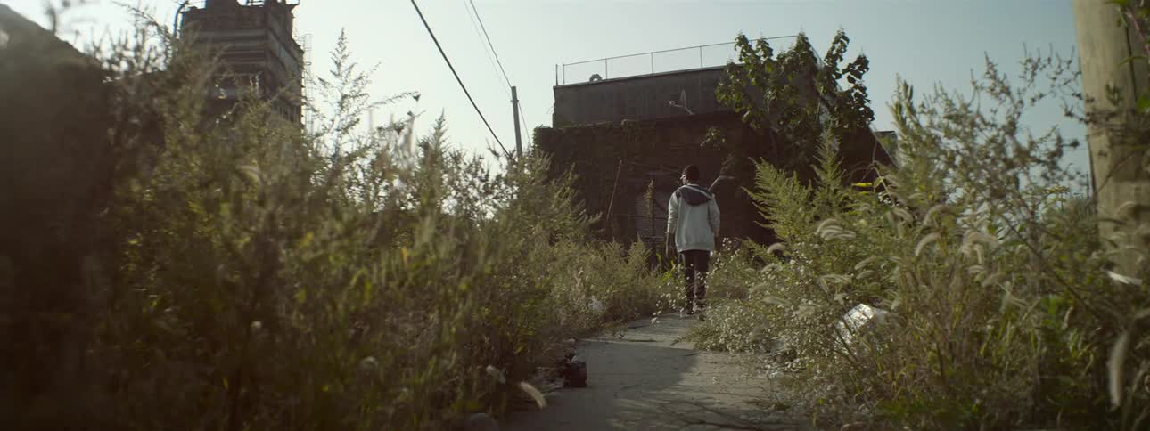 A person walking on a trail towards a building