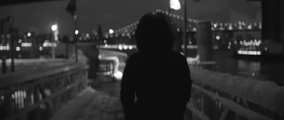 Person walking over a bridge on a windy night