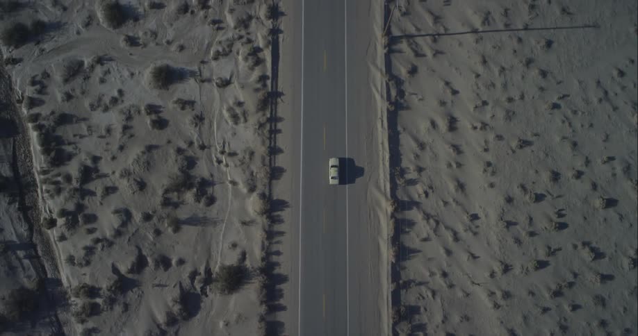 Aerial view of a vehicle traveling down an empty road