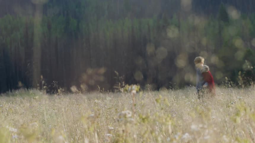 Child throws an object in a grassy field