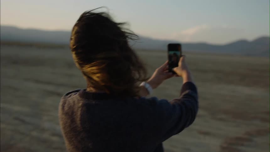Woman takes a selfie in a barren field
