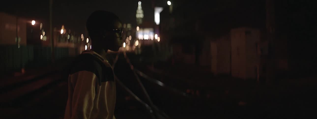 Boy walking at night in a city