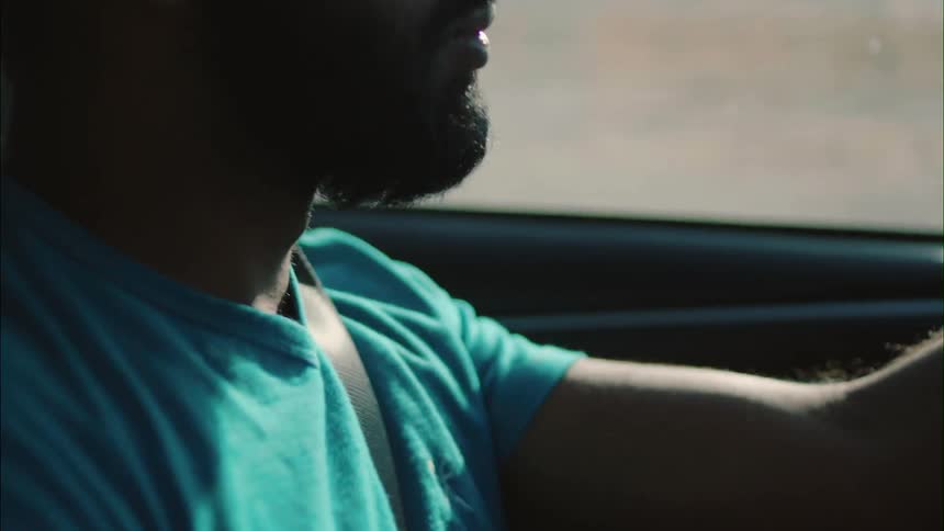 Bearded man driving on a sunny day