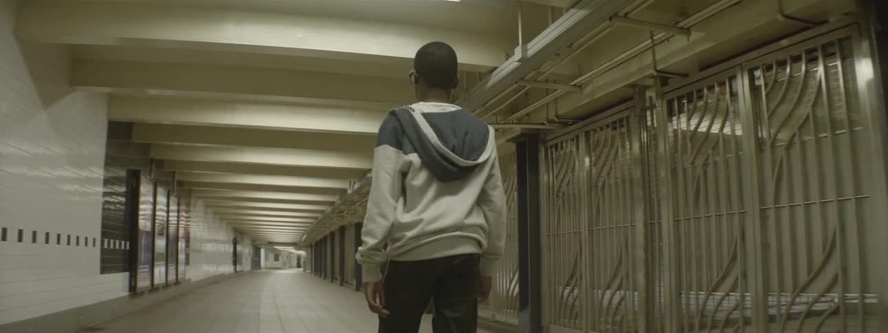 A young man walks through an empty subway station