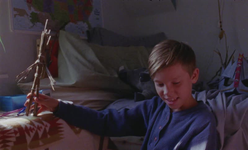 A boy and woman play on a bedroom floor