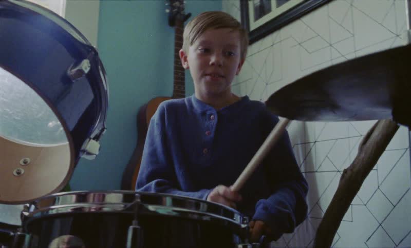 Young boy plays the drums