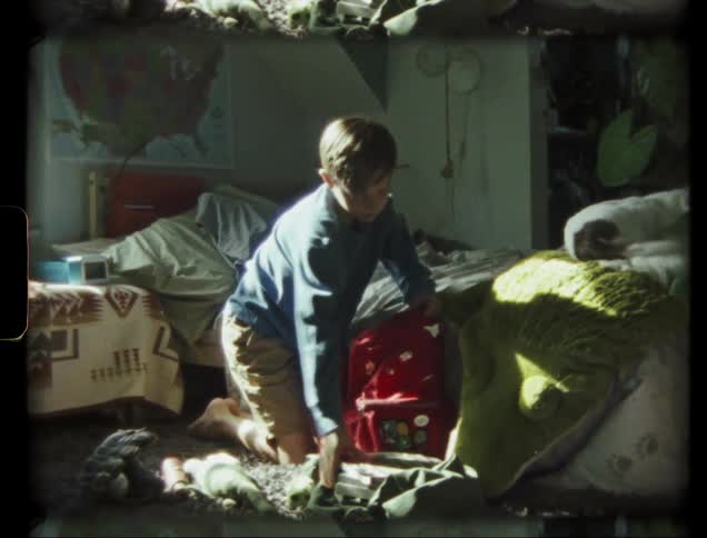 A boy puts things into a backpack