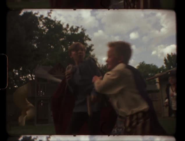 Children play gladiators in the backyard