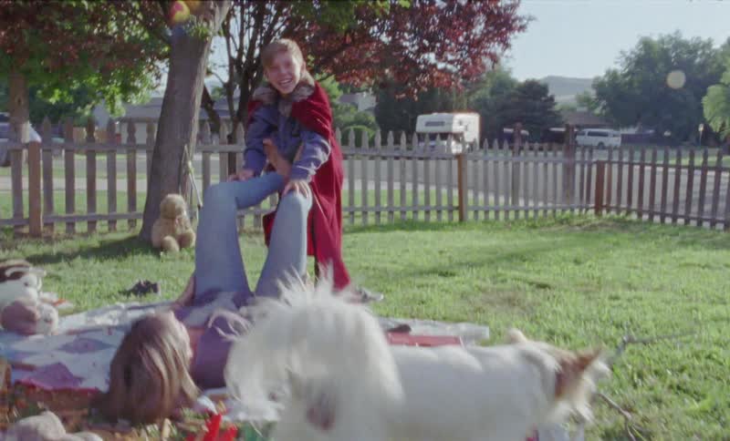 Woman and boy play on a front lawn