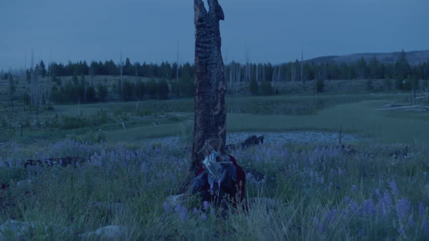 A child sits down taking off his mask