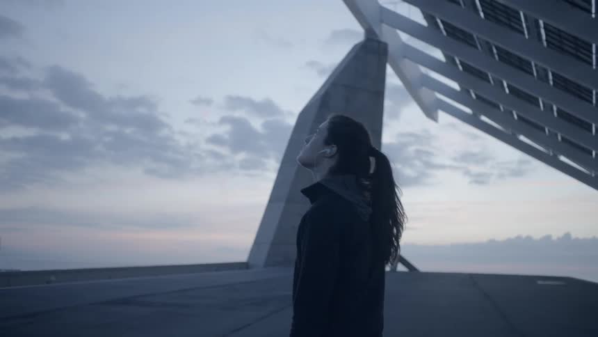 Woman stands outside at sunset
