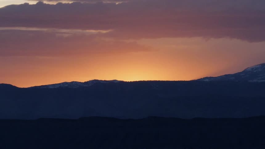 Sun setting behind hills