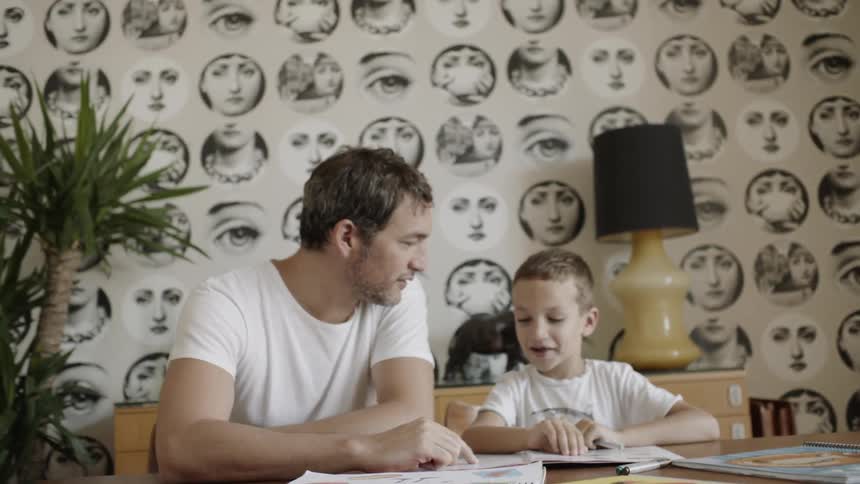 A man and boy sit at a table together