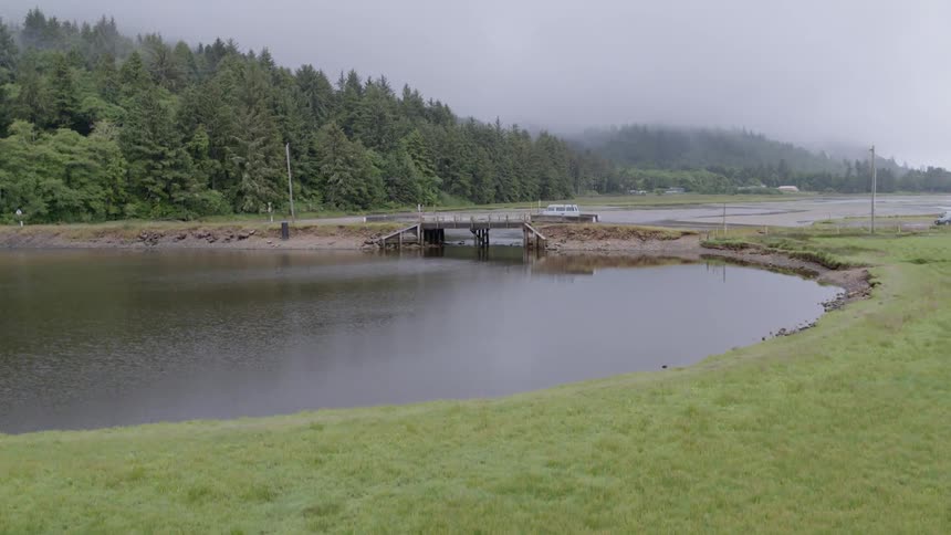 White van drives on a bridge over a river