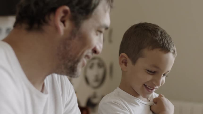 Man and young boy read a book