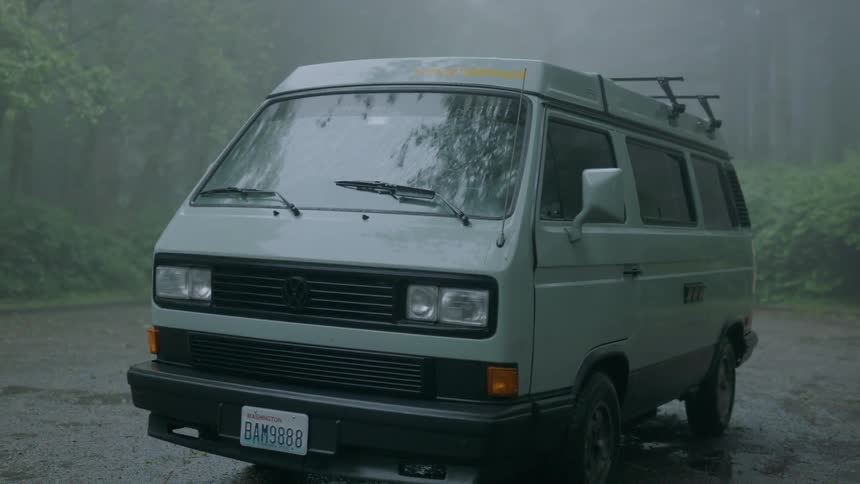 Van drives through a foggy forest