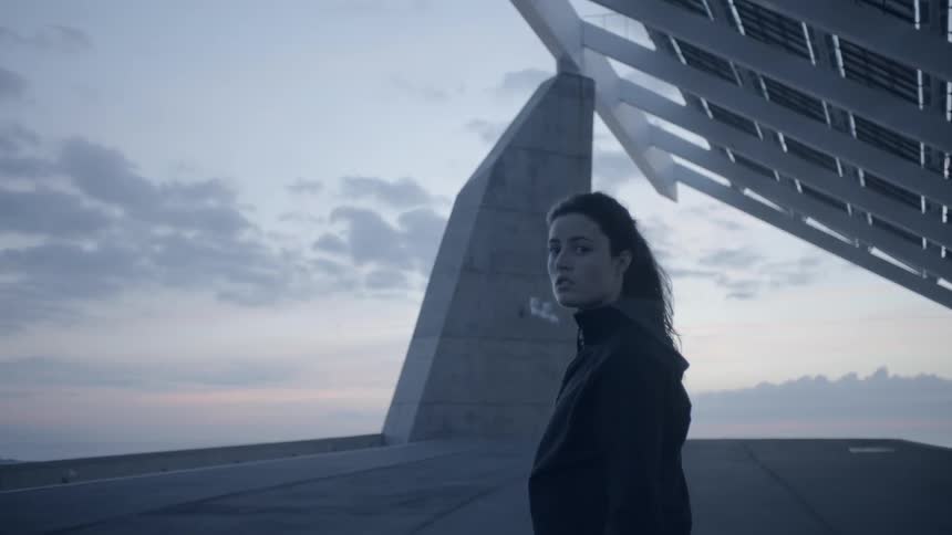 Woman stands outside at sunset