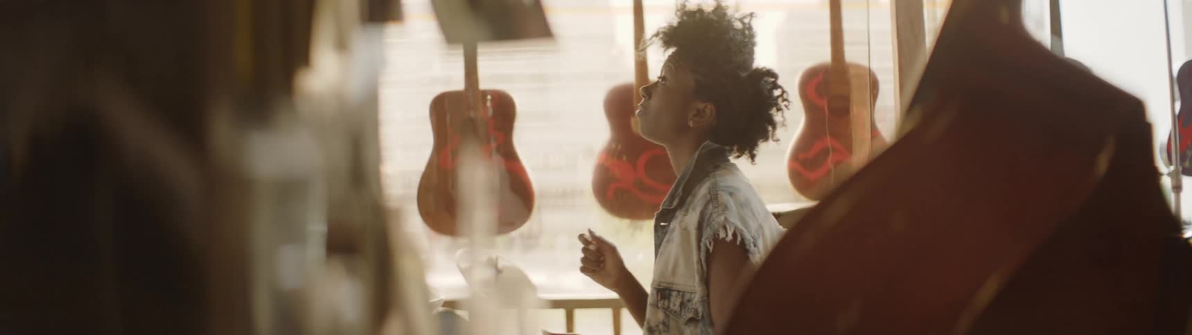 A woman is listening to a record inside a music shop in daylight