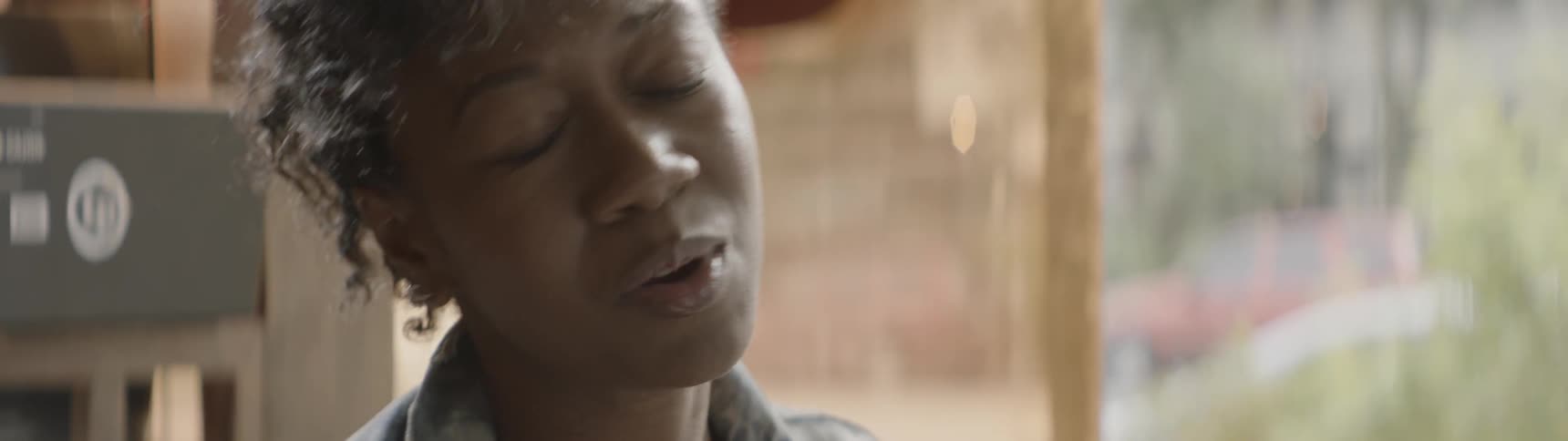 Woman sings with her eyes closed