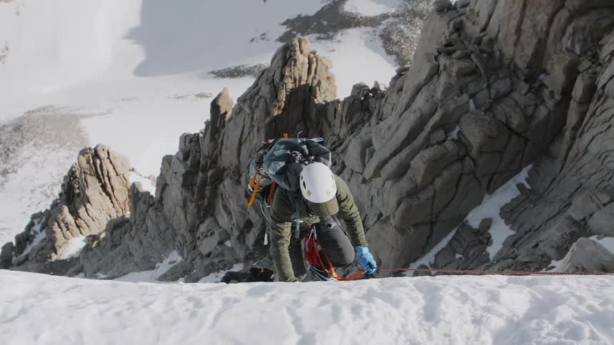Mountain climber ascending snowy mountain