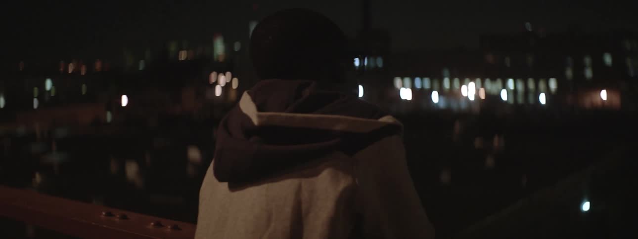 A man looking out over a cityscape at night