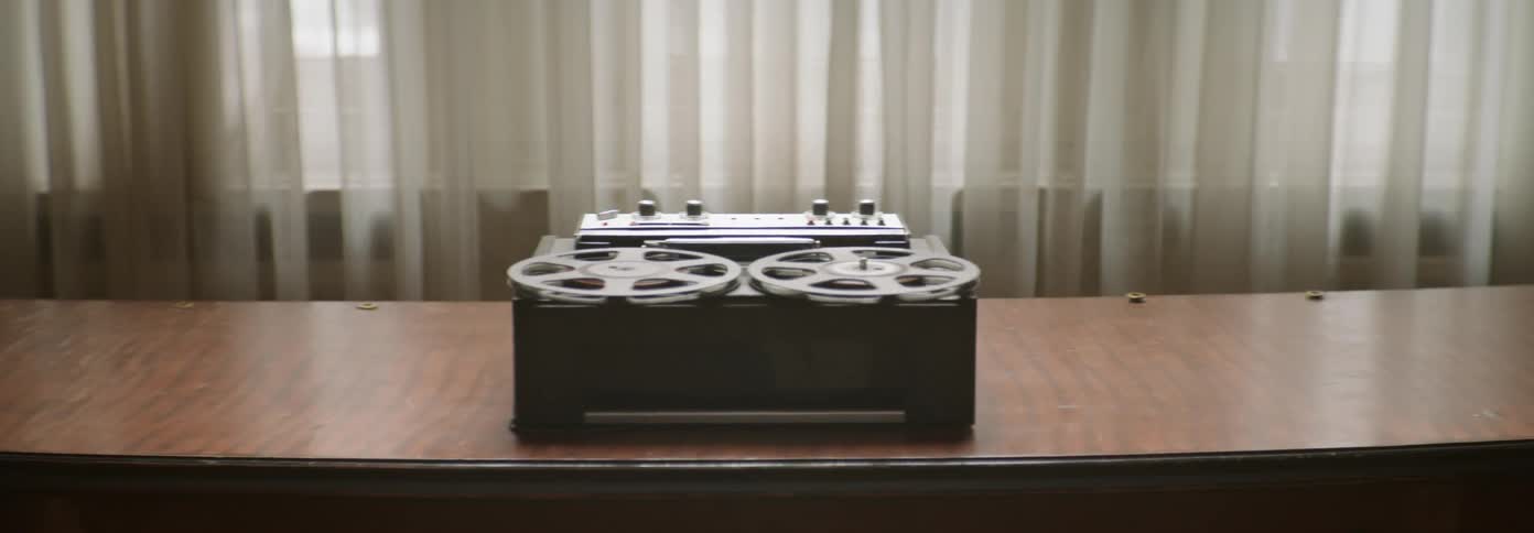 A reel to reel spins on a table top