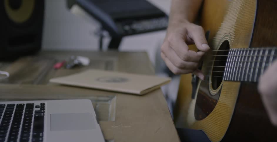 Man strums a guitar with his hand