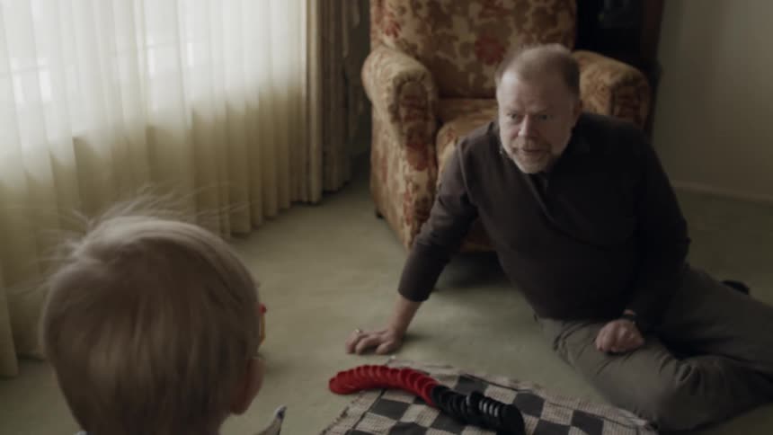 Elderly man plays with toys with a toddler