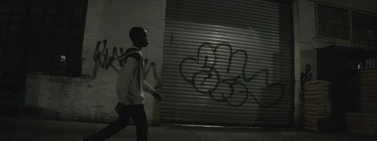 A person walking down the sidewalk at night