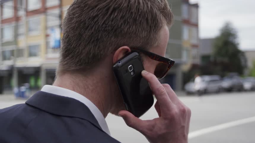 Man is talking on cell phone on city street