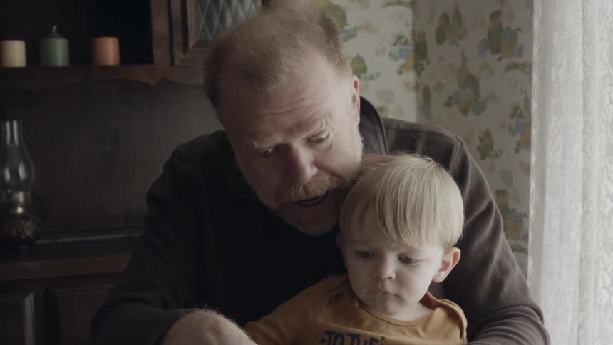 Man and toddler boy read a book
