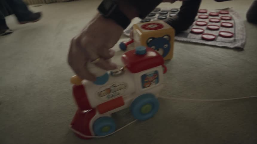 Young boy plays with a toy train engine