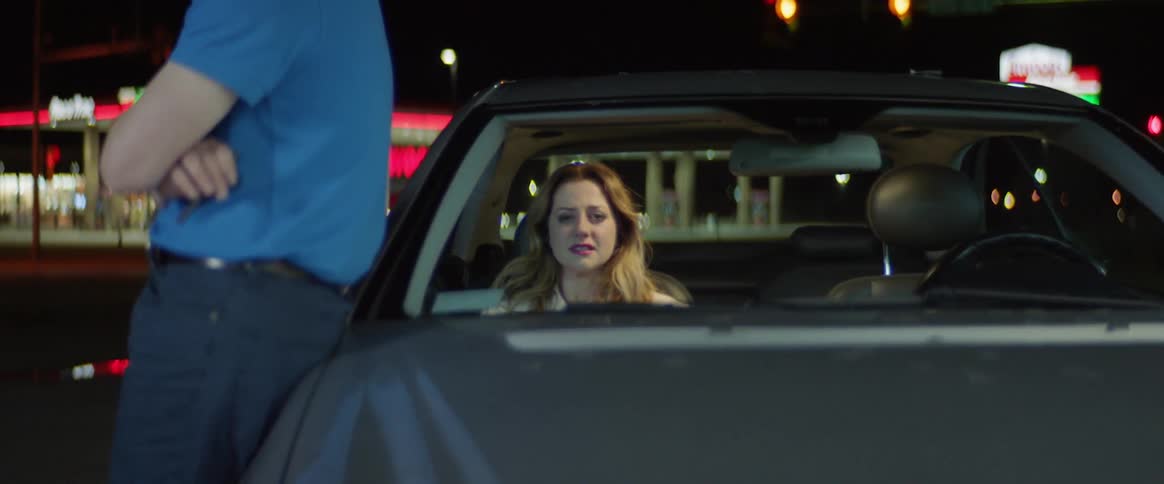 Woman cries while sitting in a parked car