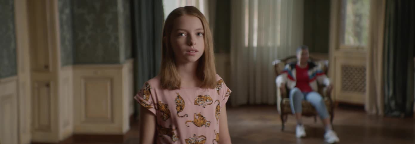 Child stands in a room smiling