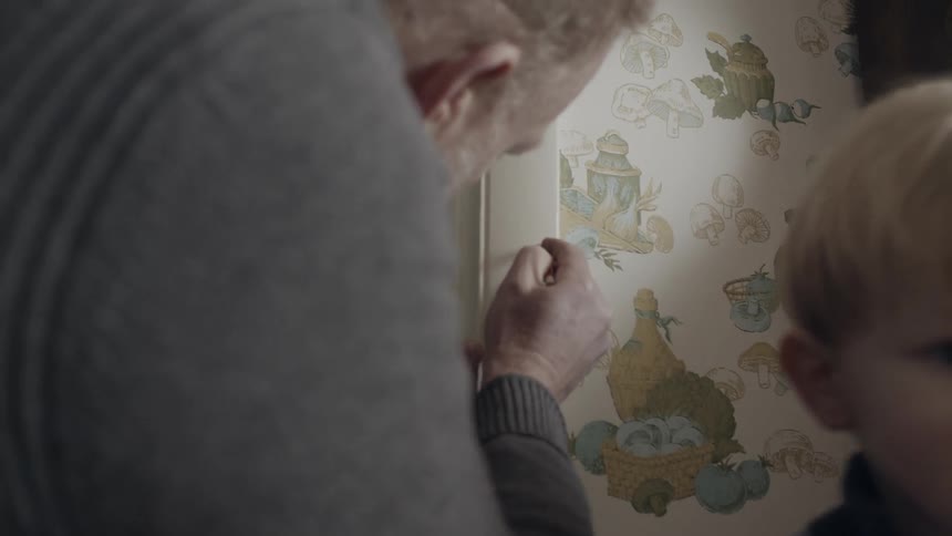 A man marks a child's height on the wall