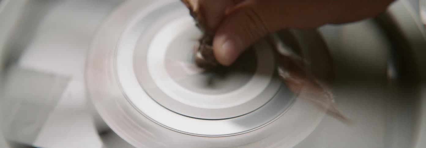 Hand touches a wrapper spinning on a disc