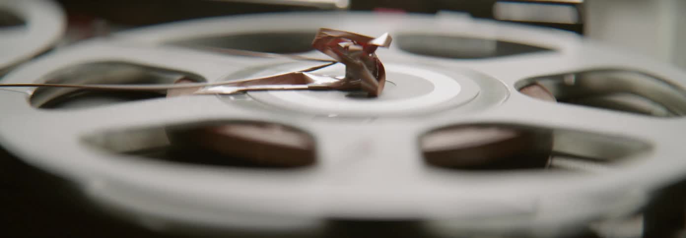A cassette reel spins as the tape is tangled on top