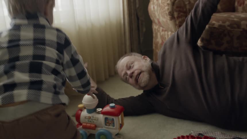 Toddler and man play in living room