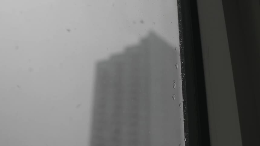 Snow falls outside a window