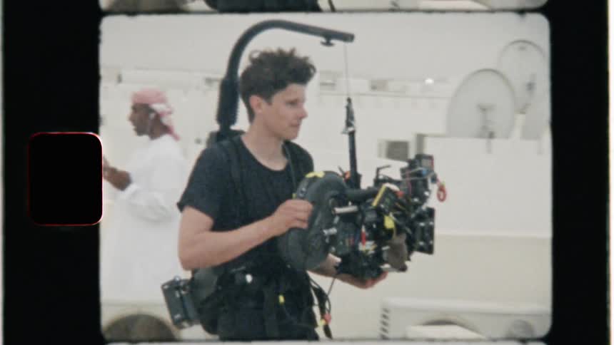 A film crew works atop a building