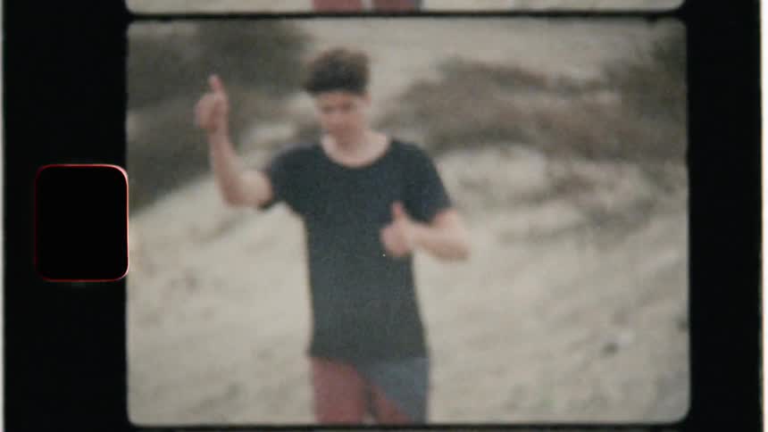 A man walking in the sand gives a thumbs up