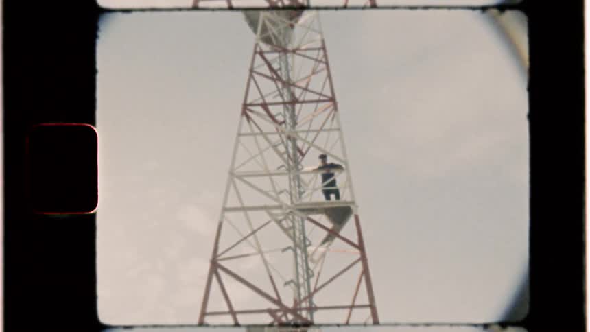 Man stands in a tower under a cloudy sky