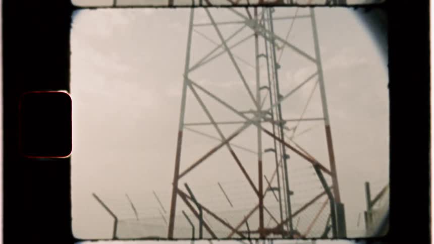 Man walks up to a large wire tower