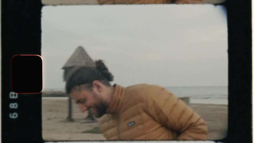Man on beach holding cell phone