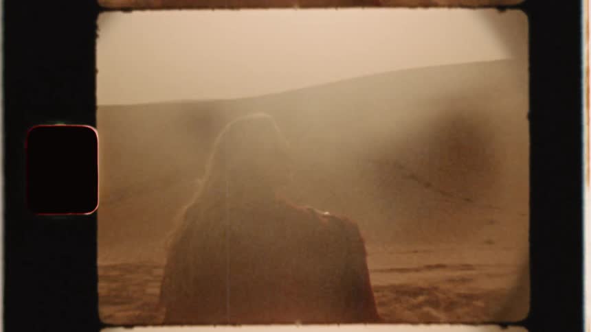 Woman sits in a sandy desert