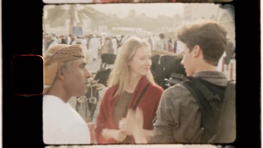 A filmmaker is talking to a man and woman in an arab market in daylight
