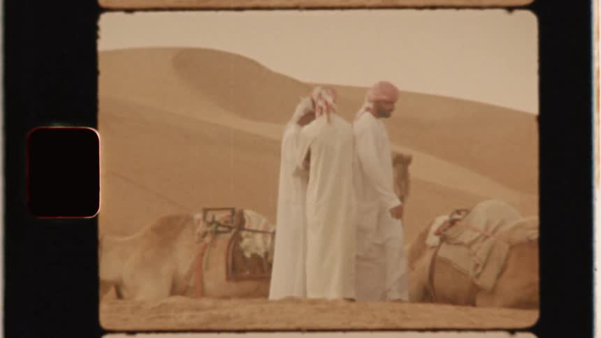Camel and men travel in a desert
