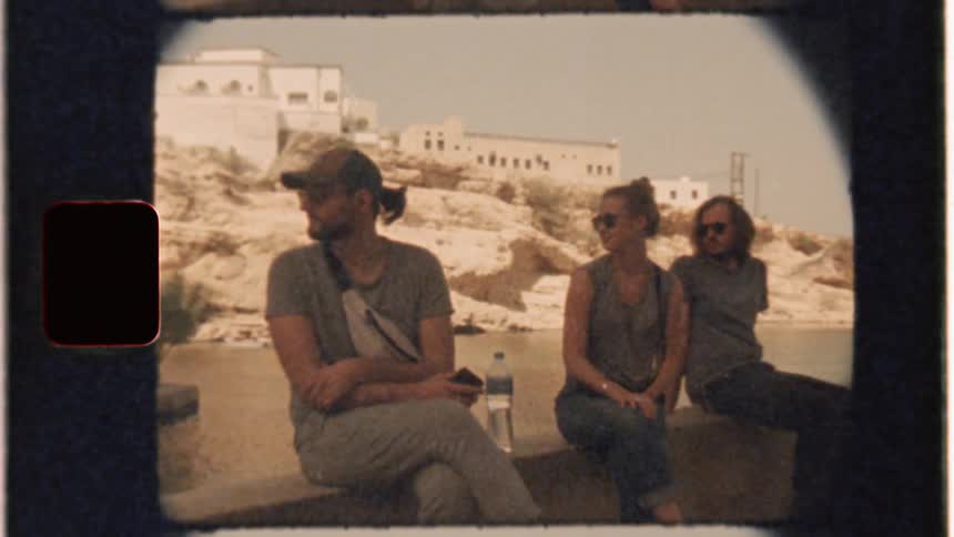 People sit on ledge looking over their shoulders