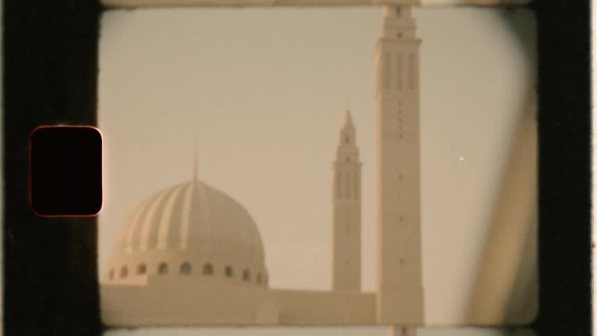 A car drives by a domed building