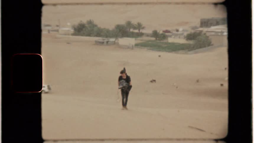 Man films while hiking up a sand dune